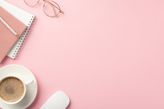 Business Concept. Top View Photo Of Workspace Notepads Pencil Cup Of Coffee On Saucer Computer Mouse And Stylish Glasses On Isolated Pastel Pink Background With Empty Space