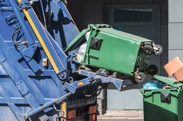 Loading garbage into a garbage truck.