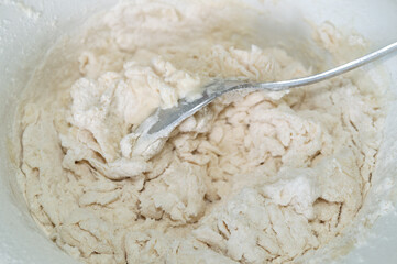 abstract background with kneading the dough in a bowl with a spoon.
