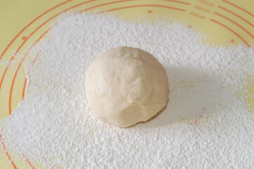ball of dough on a background of flour