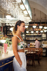 Beauty young woman standing at the bar in luxury interior