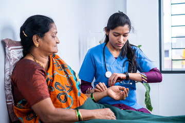 close up shot of doctor counting pulse by holding hand of sick patient - concept of health check...