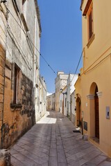 A narrow street between the old houses of Presicce, a picturesque village in the province of Lecce in Italy.