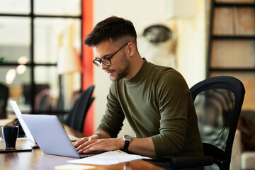 Tired businessman in office. Angry man working on laptop..