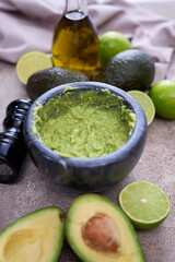 making guacamole - crushed avocado in marble mortar on grey concrete table