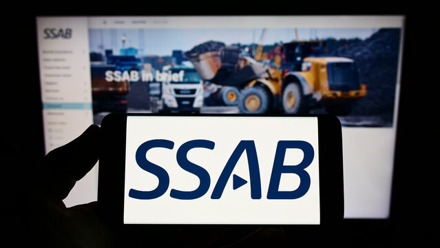 Stuttgart, Germany - 06-11-2022: Person holding smartphone with logo of Swedish steel company SSAB AB on screen in front of website. Focus on phone display.
