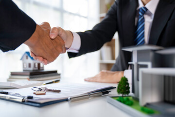 Real estate agent and customers shaking hands together celebrating finished contract after about home insurance and investment loan, handshake and successful deal