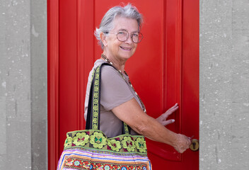 Fototapeta premium Senior old aged woman opening the new house apartment looking at camera, older retired caucasian female real estate owner make sale purchase property deal concept
