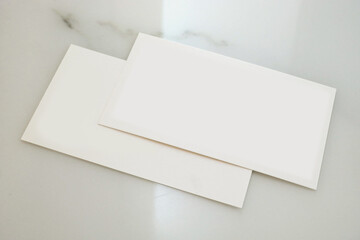 Two white business cards on a marble table