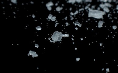 salt crystals are scattered over a black background close-up