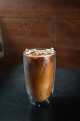 Ice coffee on a table with cream being poured into it showing the texture