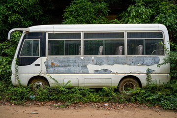 An old minibus passenger car parked in an abandoned industrial park