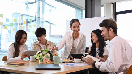 Mature business team leader talking, giving instructions to diverse staff at corporate meeting