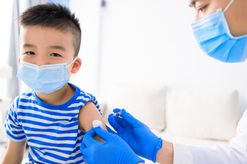 Medical Doctor injecting child with vaccine at clinic or hospital