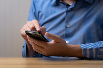 Businessman using smartphone for business and find online sales information, ideas for doing business online. Work using mobile phone typing computer mobile chat