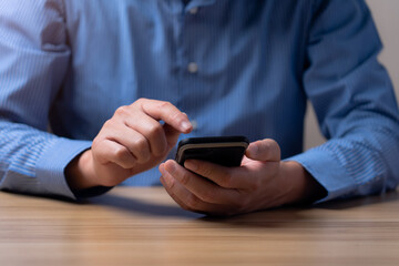 Businessman using smartphone for business and find online sales information, ideas for doing business online. Work using mobile phone typing computer mobile chat