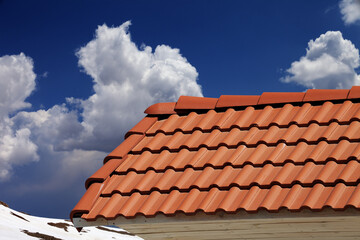 Roof tiles and blue sky with clouds