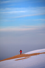 Hiker on edge of cliff in sunrise