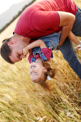 Happy father playing and carrying his daughter on hands.Mature man playing with his little daughter...