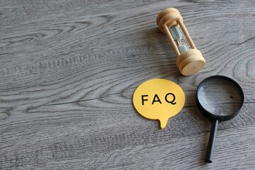 Hourglass, magnifying glass and speech bubble with text FAQ. Frequently asked question concept
