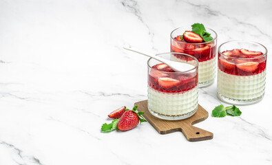 Traditional Italian dessert panna cotta with strawberry jelly on a light background. Summer yogurt...