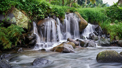 beautiful natural waterfall, water flows into the river
