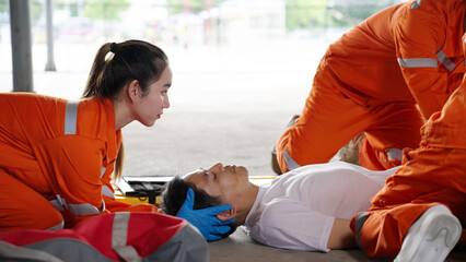 Emergency medical technician Asian woman (EMT) or paramedic team is holding manual stabilization of...