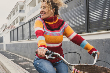 Happy mature young woman riding a bike and smiling enjoying outdoor active healthy leisure...