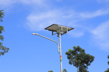 Naklejka na ściany i meble The street light uses solar powered technology against the background of a bright blue sky