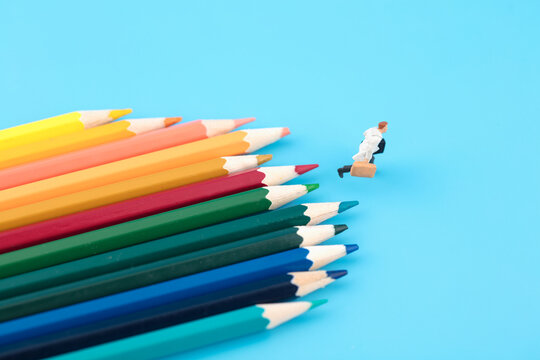 People running in front of miniature creative color pencils