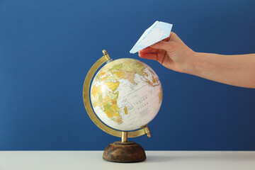Concept of travel and adventure, globe and female hand with paper plane