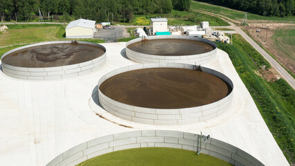 Tanks with liquid manure on the territory of a livestock farm. Aerial view.