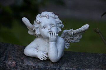 Fototapeta na wymiar Kleiner Engel auf einem Grabstein auf dem Friedhof
