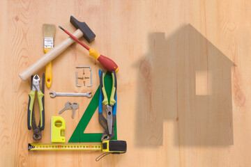 forma de casa realizada con herramientas sobre un panel de madera con espacio para escribir texto