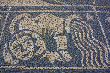 Traditional pattern cobblestone pavement (calçada portuguesa) with image of fish zodiac sign in...