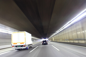 高速道路のトンネルを走行するトラックと車