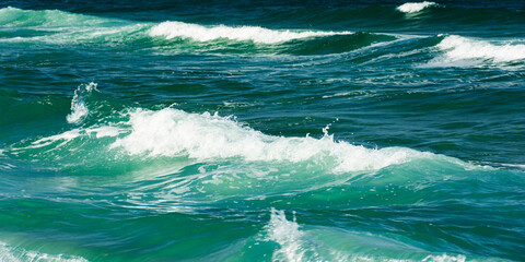 green wave background in natural day light. blurred water and foam texture