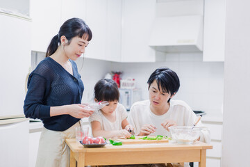 子供と一緒にクッキングをする家族