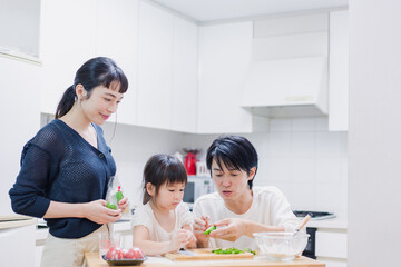 子供と一緒にクッキングをする家族