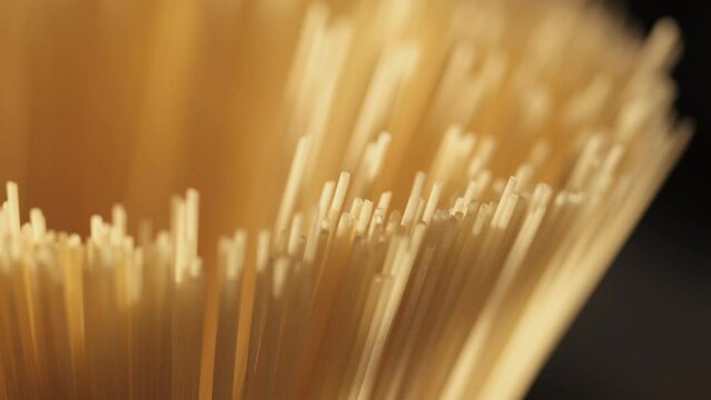 Background Of Spaghetti Pasta. Uncooked Italian Pasta Golden Rotating Backdrop. Healthy Eating Concept. Raw Dried Organic Pasta. Long Macaroni, Rotating Background. Italian Culture