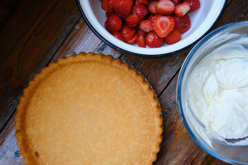 Delicious biscuit and creamy whipped cream on a wooden background. Freshly baked dessert for tea or a holiday. Sweet heart of whipped cream