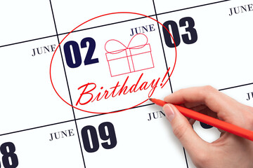 The hand circles the date on the calendar 2 June, draws a gift box and writes the text Birthday. Holiday.