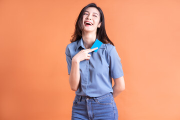 Young Asian business woman posing on orange background