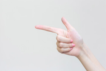 Beautiful female hand shows finger as a pointing symbol in manicure concept to present something on the white background.