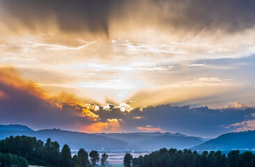 forest landscape of the province of Barcelona (Spain), at sunset with smoke from a distant fire