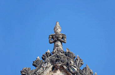 Amazing Deity Sculpture on the Pediment Top of the Old Ordination Hall of Wat Chomphuwek Buddhist Temple, a National Ancient Monument in Nonthaburi, Thailand 