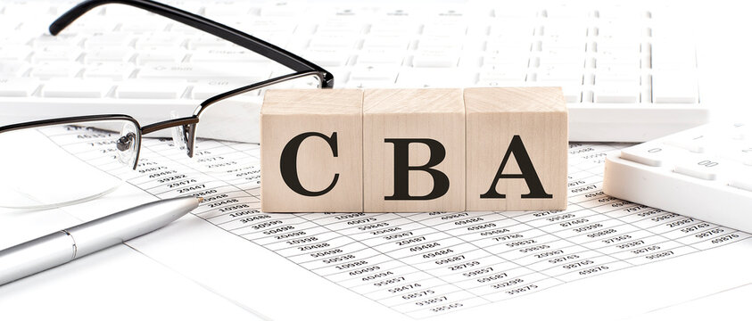 CBA written on a wooden cube with keyboard , calculator, chart,glasses.Business concept