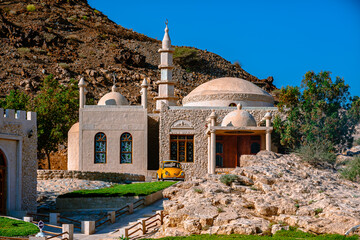Classic beetle orange car and historical mosque in Dibba Fujairah, UAE - Powered by Adobe
