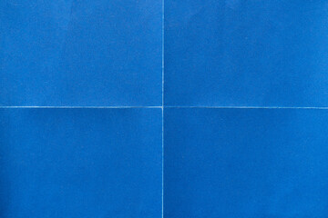 Blue paper background with creases that separates paper into four parts