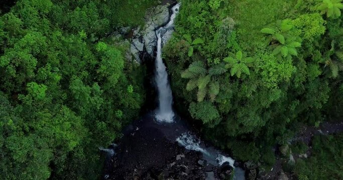 Aerial view from drone flying over nature view of waterfall in the middle of forest. nature is still beautiful named Kedung Kayang Waterfall  in Central Java, Indonesia